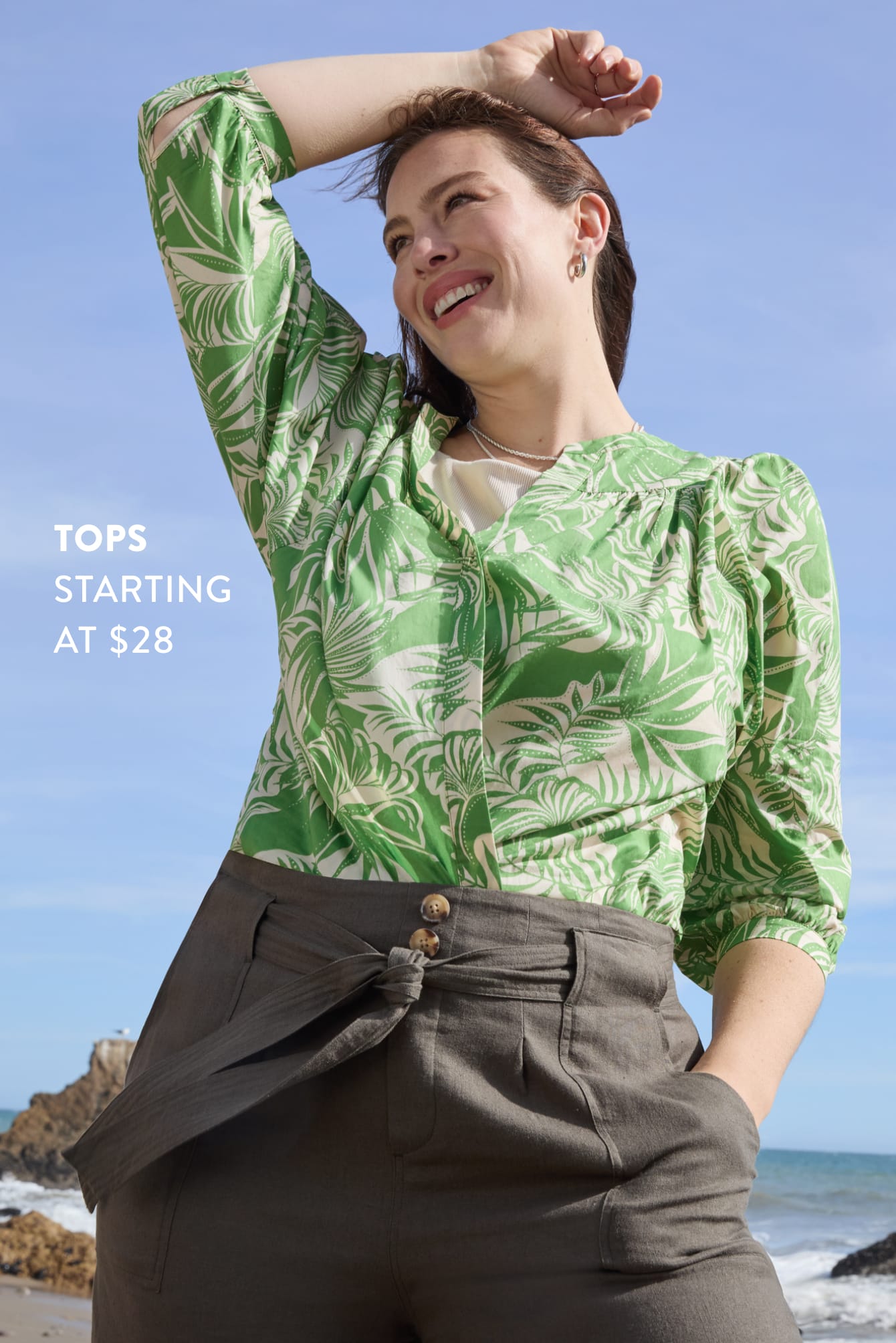 Tops starting at $28. Woman on beach wearing printed Stitch Fix top and wide-leg pants