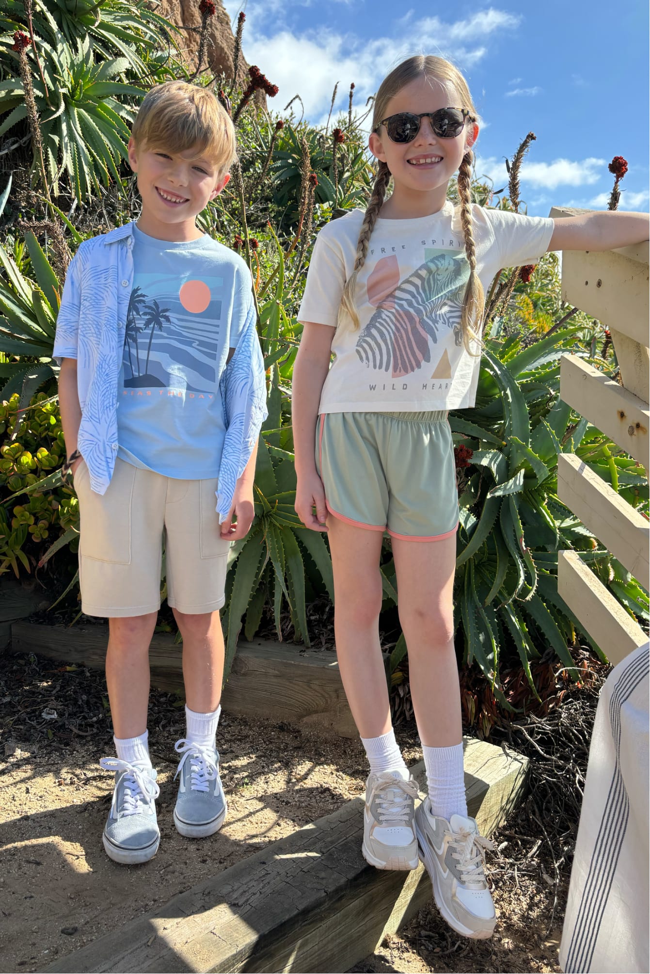 Two kids outside wearing bright Stitch Fix kids graphic tees and shorts