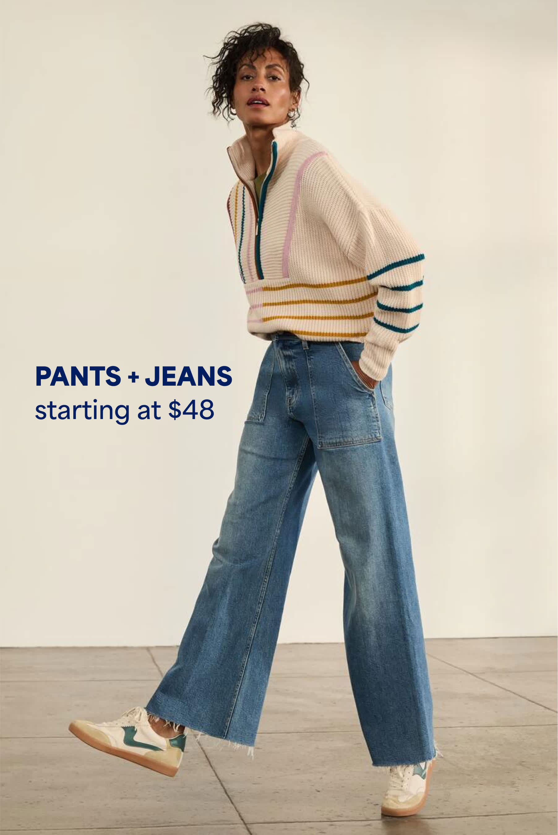 Model wearing Stitch Fix women’s clothes: wide-leg jeans and colorful sneakers.