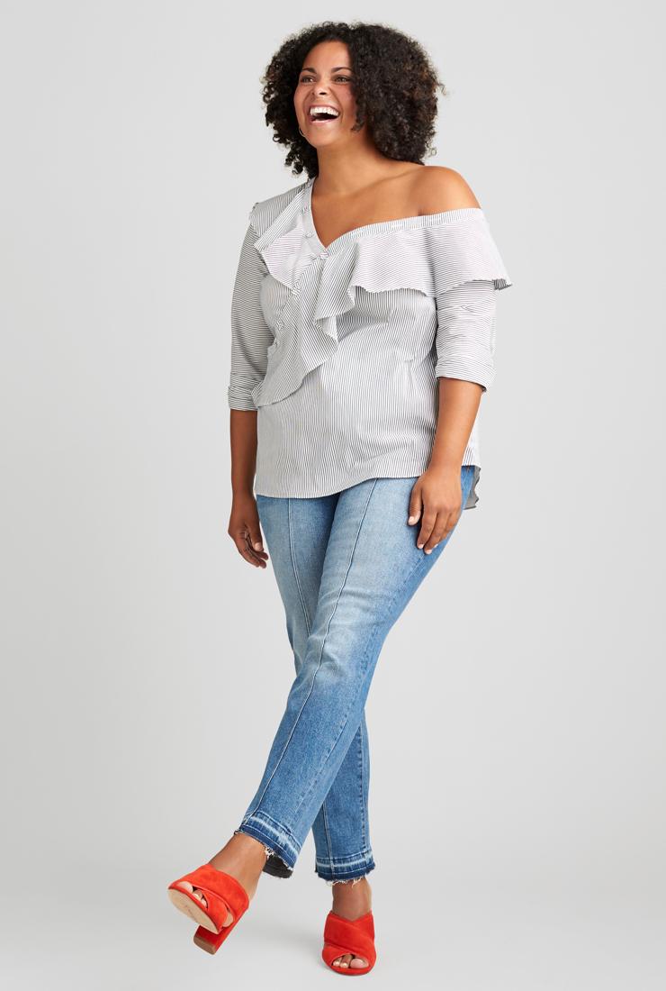 Pale off-the-shoulder top with ruffle detail, jeans and red shoes.