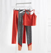 Plus size activewear clothing including orange and grey leggings and orange crop top.