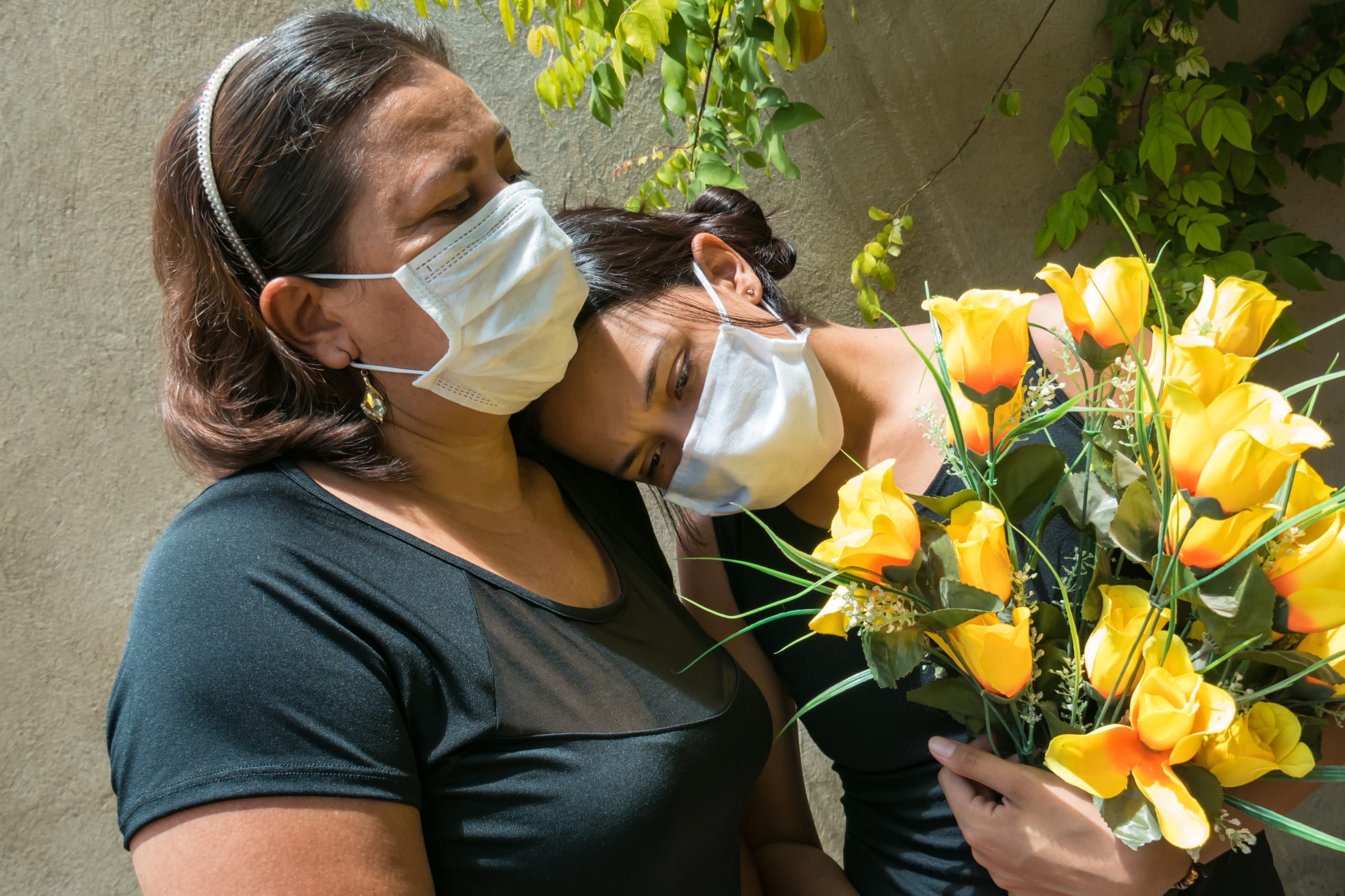 Women,Mourning,Those,Lost,To,The,Coronavirus,,Wearing,Face,Masks,