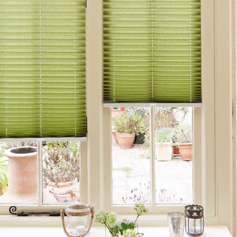 Arena green pleated blinds on a sash window