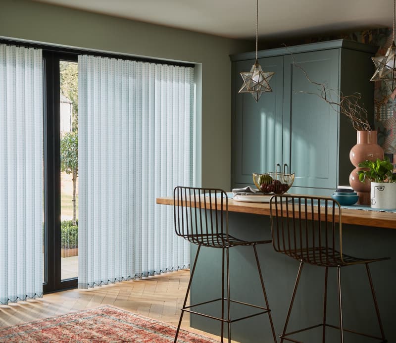 Arena Romain Turquoise vertical blinds on bi-fold doors in a kitchen