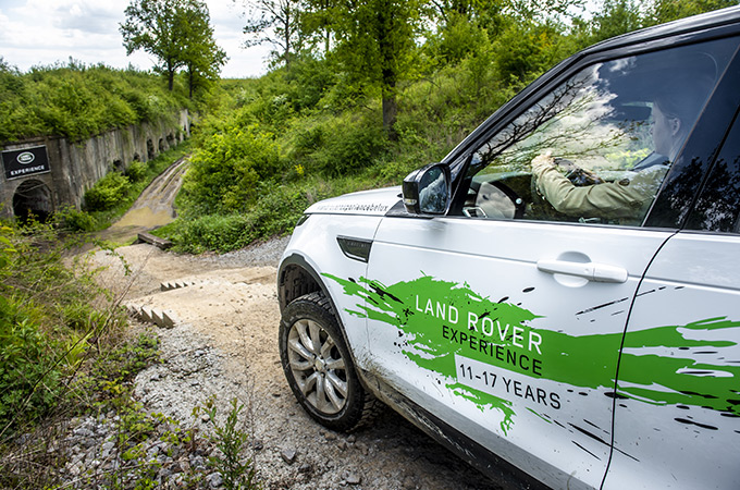 Un gros plan montrant l'avant gauche d'un véhicule blanc roulant dans les bois.
