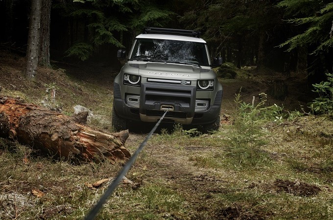 Un Defender remorqué dans les bois.