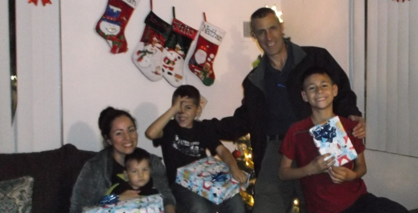 Paul Mauer from StaxUP Storage and a family in need with their Christmas gifts.