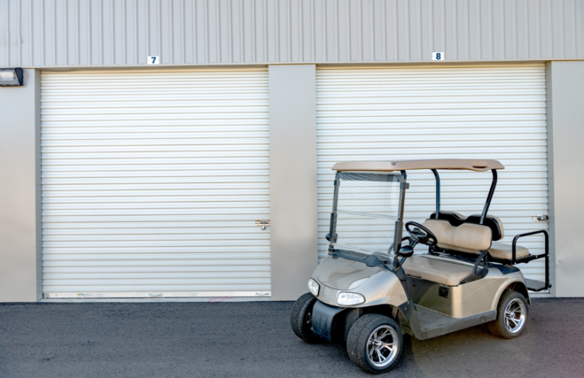 golf cart parked in front of 2 closed storage units