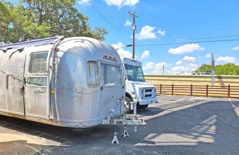 A truck and RV being stored in outdoor parking spaces at a Lockaway Storage facility.