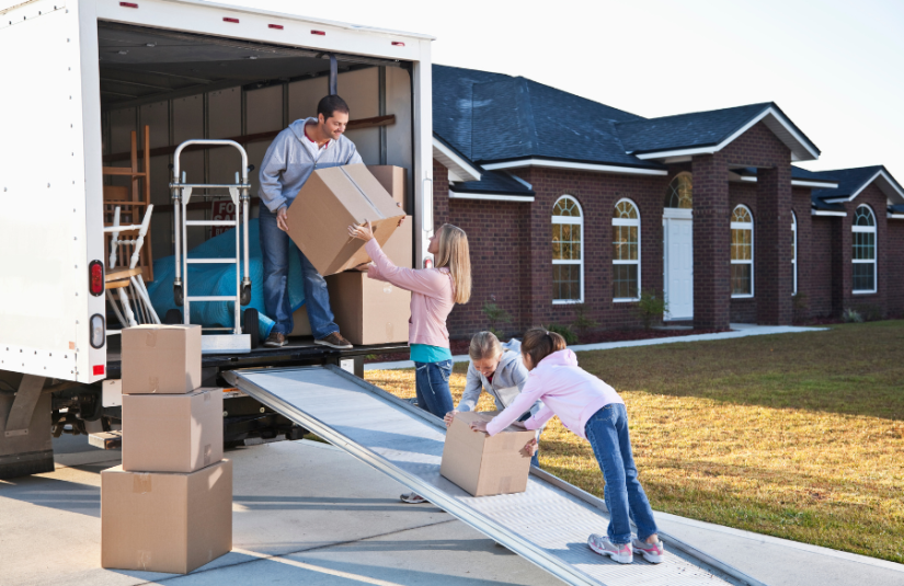 Family of 4 moving boxes into a moving truck
