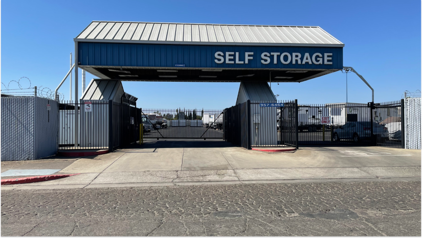Arco's Stockton secure entry with gated access, barbed wire perimeter, blue canopy with white text "Self Storage"