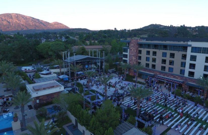 A live music performance outside of Viejas Casino & Resort. It is sunset and the mountains are visible in the background.