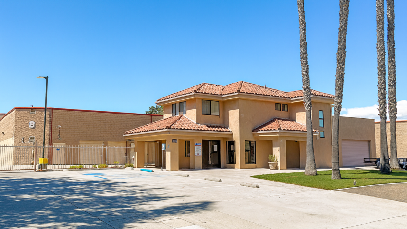 StaxUP Storage San Marcos facility exterior on E Mission Rd with gated access, office building, and spacious driveways under clear Southern California skies.