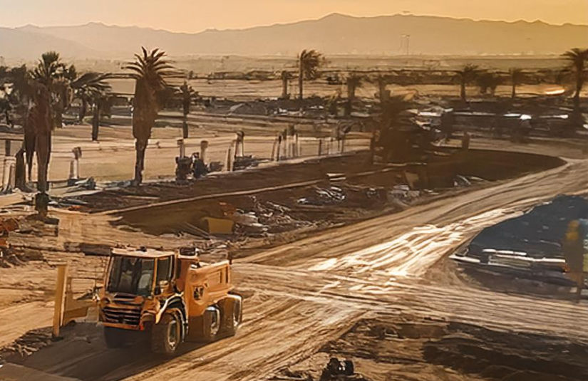 The image shows a dump truck driving in a construction zone in Bakersfield California