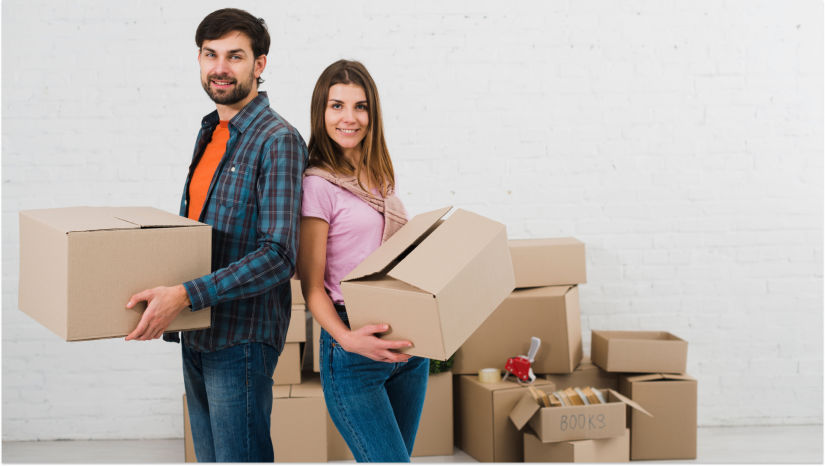 couple in pink and blue and orange holding storage boxes and smiling at camera