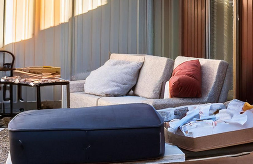 The image shows deteriorated furniture outside of a self storage facility.