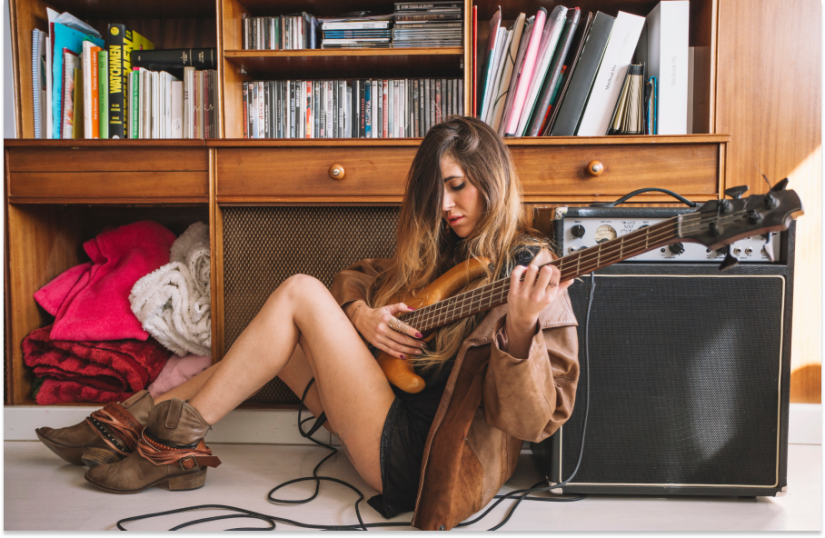 girl playing guitar on floor