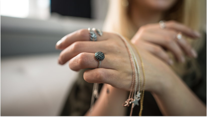 woman with her hand towards the camera ith rings and bracelets on