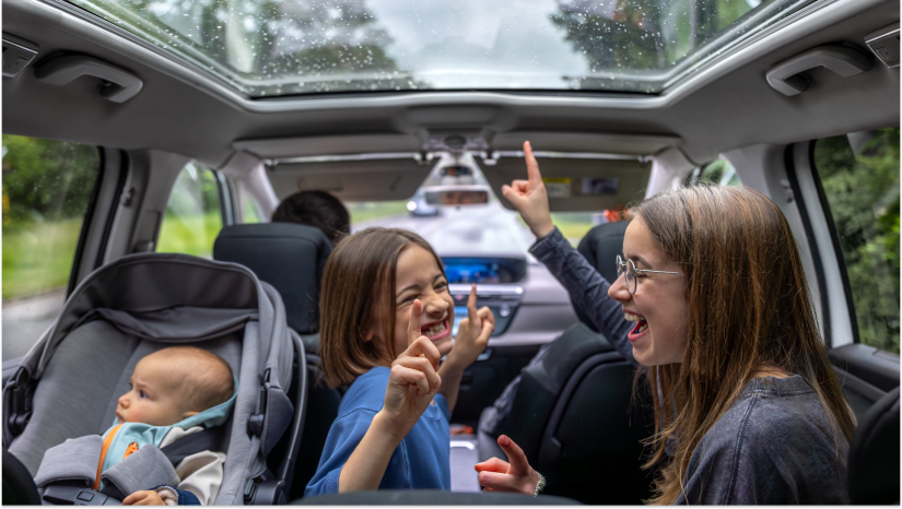 kids dancing in a car and a baby in a carseat looking out of the window