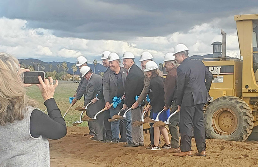 Digging up the first shovelful of dirt for the groundbreaking ceremony.