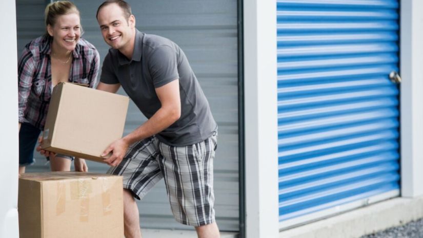Man and women carrying box to put in storage unit
