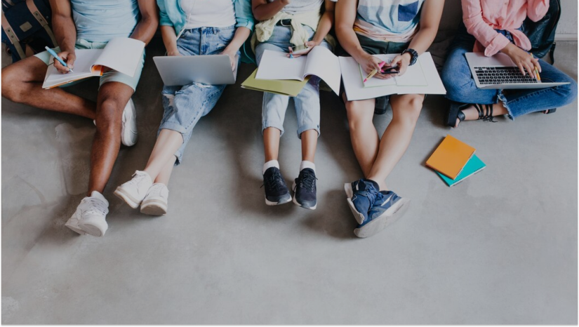 Students sitting with notebooks and laptops