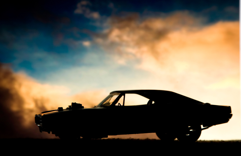 An antique car silhouetted against a sunset.