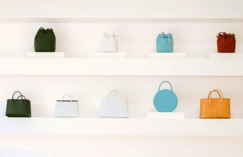 A line of handbags in different shapes and colors.