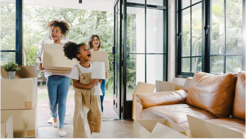 family moving into a home looking happy with storage boxes and various items