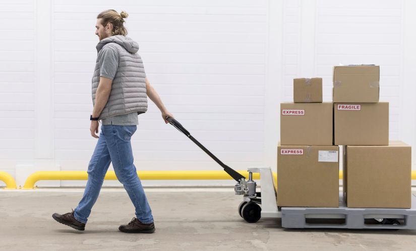 man walking with a trolley carrying storage boxes