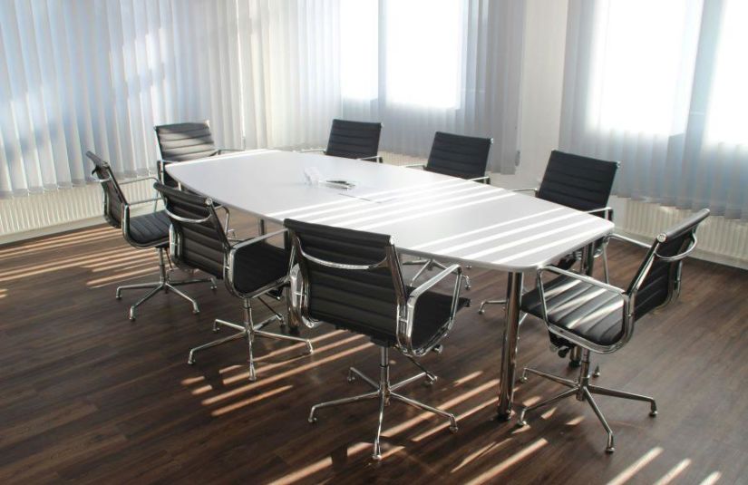 A conference room, with eight rolling chairs surrounding an empty conference table.