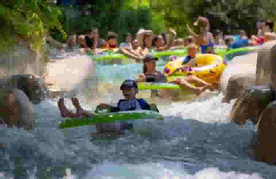 Kids and families ride inner tubes down the rapids at Schlitterbahn Waterpark.