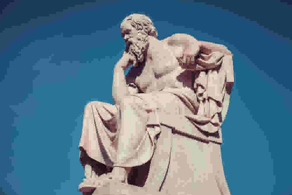 A statue of Socrates sitting and thinking.