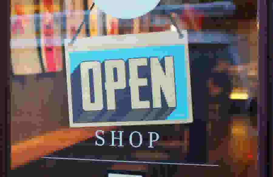 An "Open" sign hanging in a shop window.