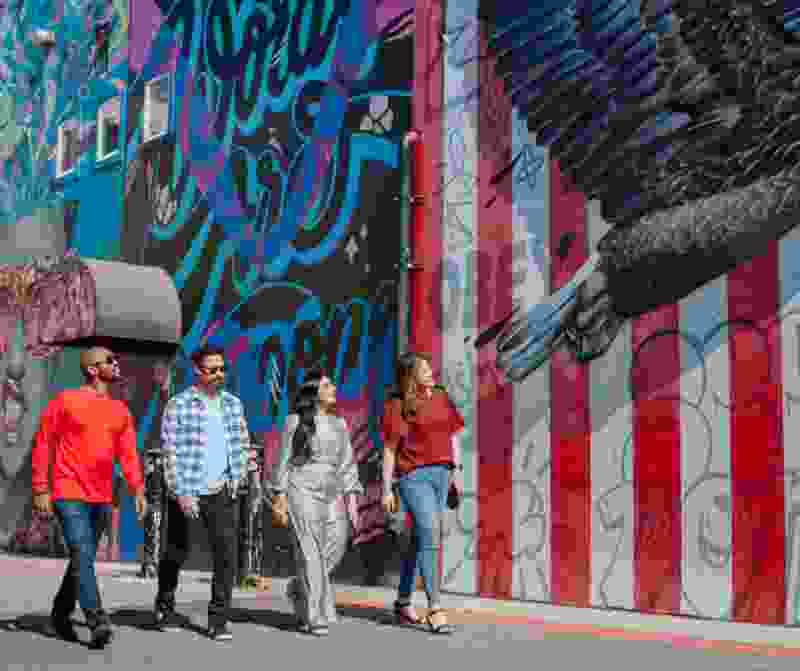 people walking looking at murals in modesto