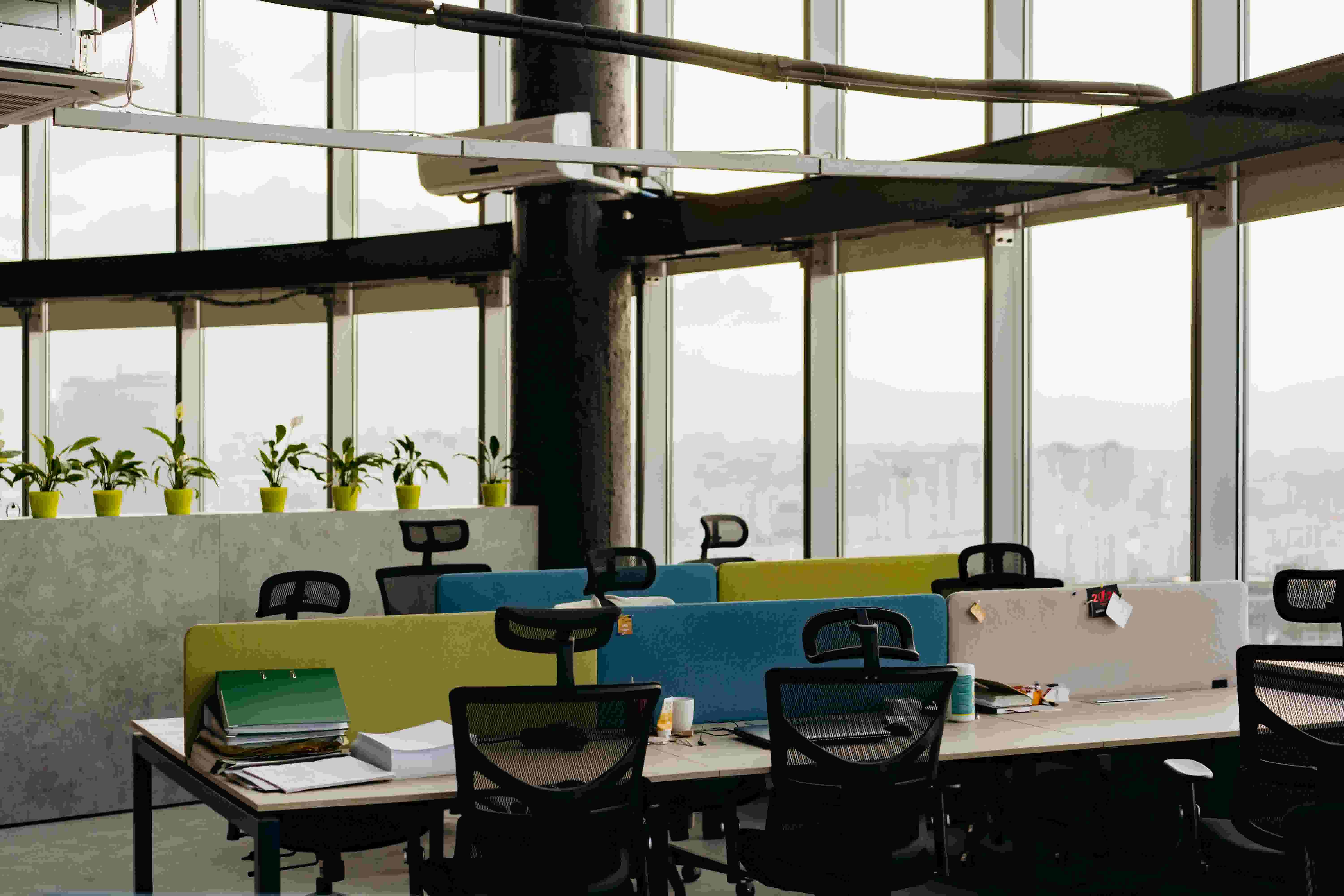 An office space with rolling chairs seated at desks.