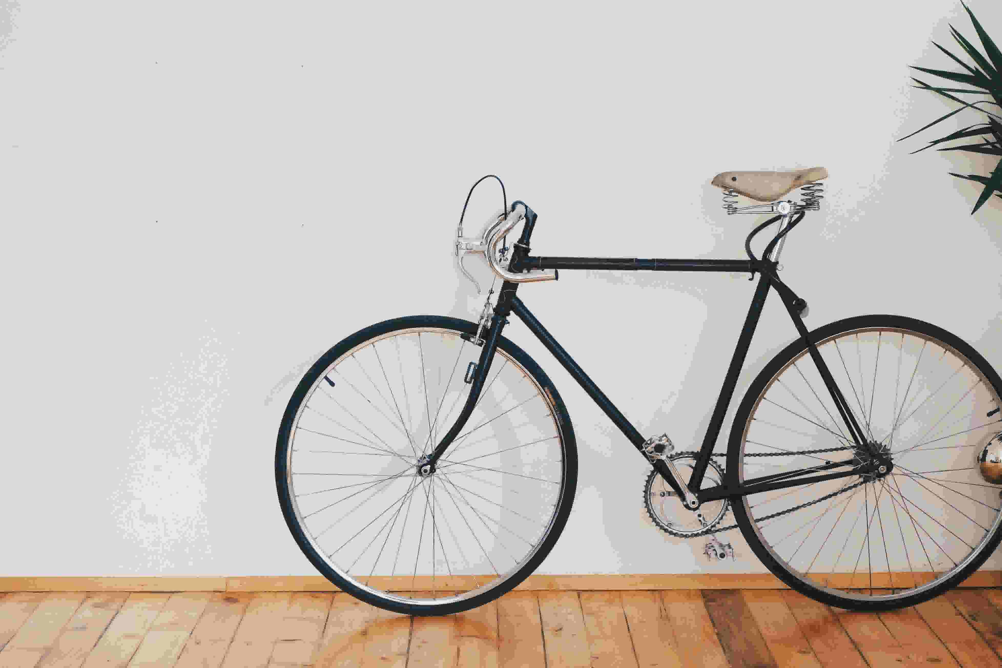 A bicycle propped against a white wall