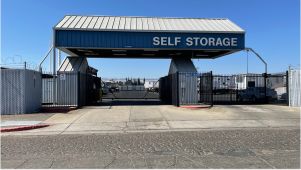 Arco's Stockton secure entry with gated access, barbed wire perimeter, blue canopy with white text "Self Storage"