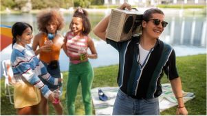 friends in a park wearing bright colors and holding a boom box above thier head