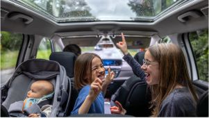 kids dancing in a car and a baby in a car seat