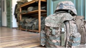 military backpack and hat sitting neatly on the floor