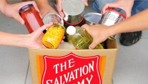 Hands putting food in a salvation army food drive bag