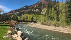 photo of a scenic river with mountains and trees