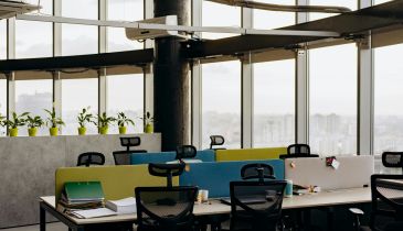 An office space with rolling chairs seated at desks.