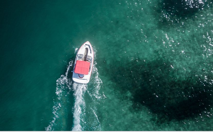 boat with a red umbrella on top of dark blue water