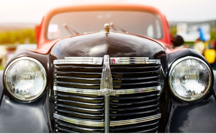front closeup of a classic car with a red and black exterior