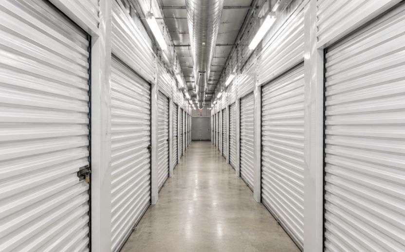 Climate-controlled storage hallway with clean indoor units, polished concrete floors, and overhead ventilation in a secure temperature-controlled facility.