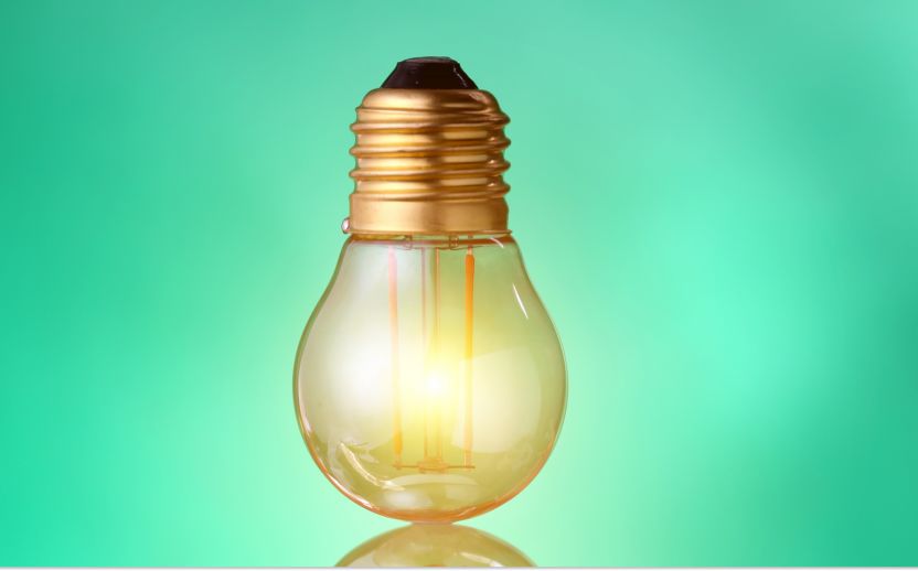 upsidedown yellow lightbulb with a green background