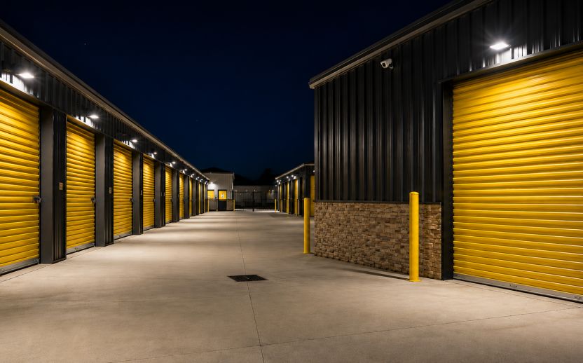 Secure self-storage facility at night with illuminated drive aisles and 24-hour access for customers.