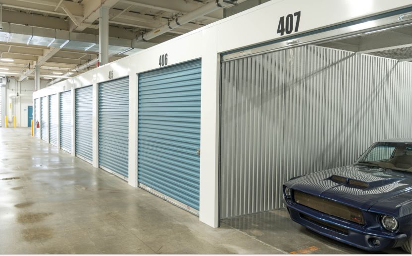 classic car inside of a storage unit with door rolled up with an interior drive thru storage unit facility